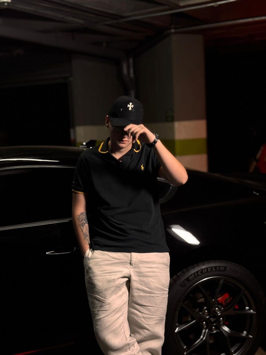 Cliente con la gorra Tres Coronas junto a un deportivo de noche